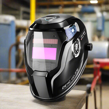 SmartGearPros DEKO solar-powered auto-darkening welding helmet with a sleek black design and protective visor that is showcased inside a fabrication shop