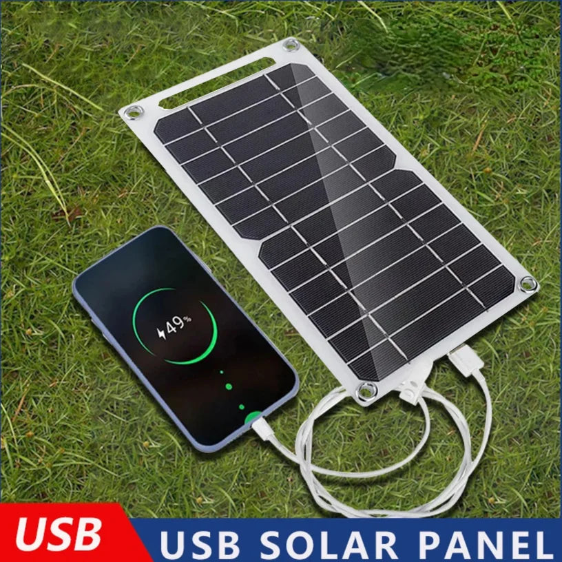 SmartGearPros Portable Solar Panel charging a smartphone on the grass with USB connection.