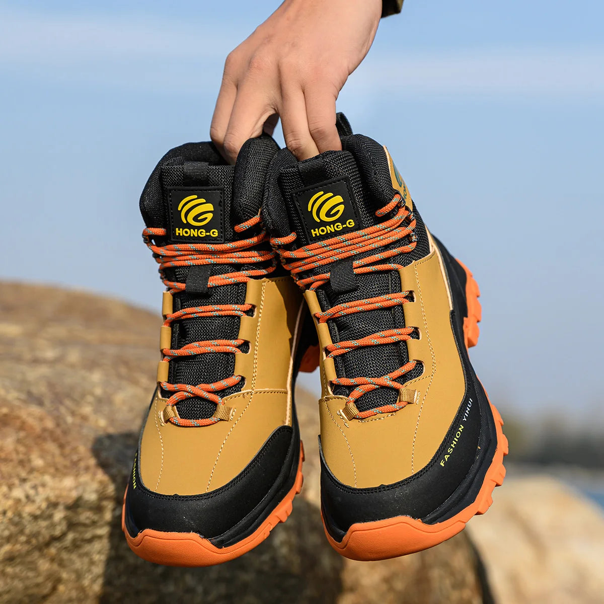 Lightweight protective work boots being held in hand.