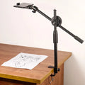 The overhead tripod phone mount is being used to film or take a photo from above of a drawing.